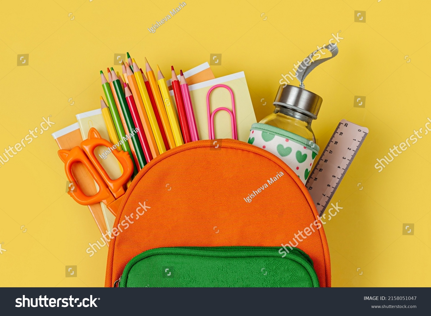 Kids Backpack with school bus on yellow background. Opened School backpack with stationery. Primary School or kindergarten.  #2158051047