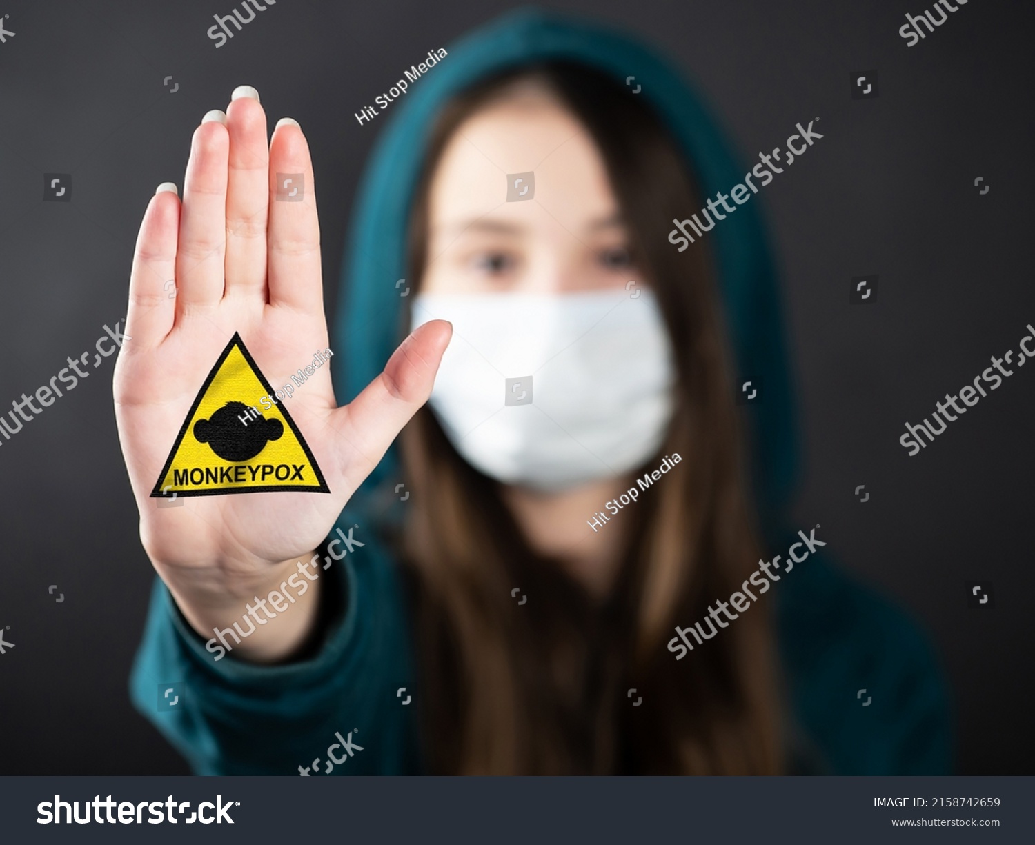 MONKEYPOX.Teenage girl wearing a mask to protect against diseases shows a hand gesture to stop the outbreak of the MONKEYPOX virus. Virus, epidemic, disease. #2158742659