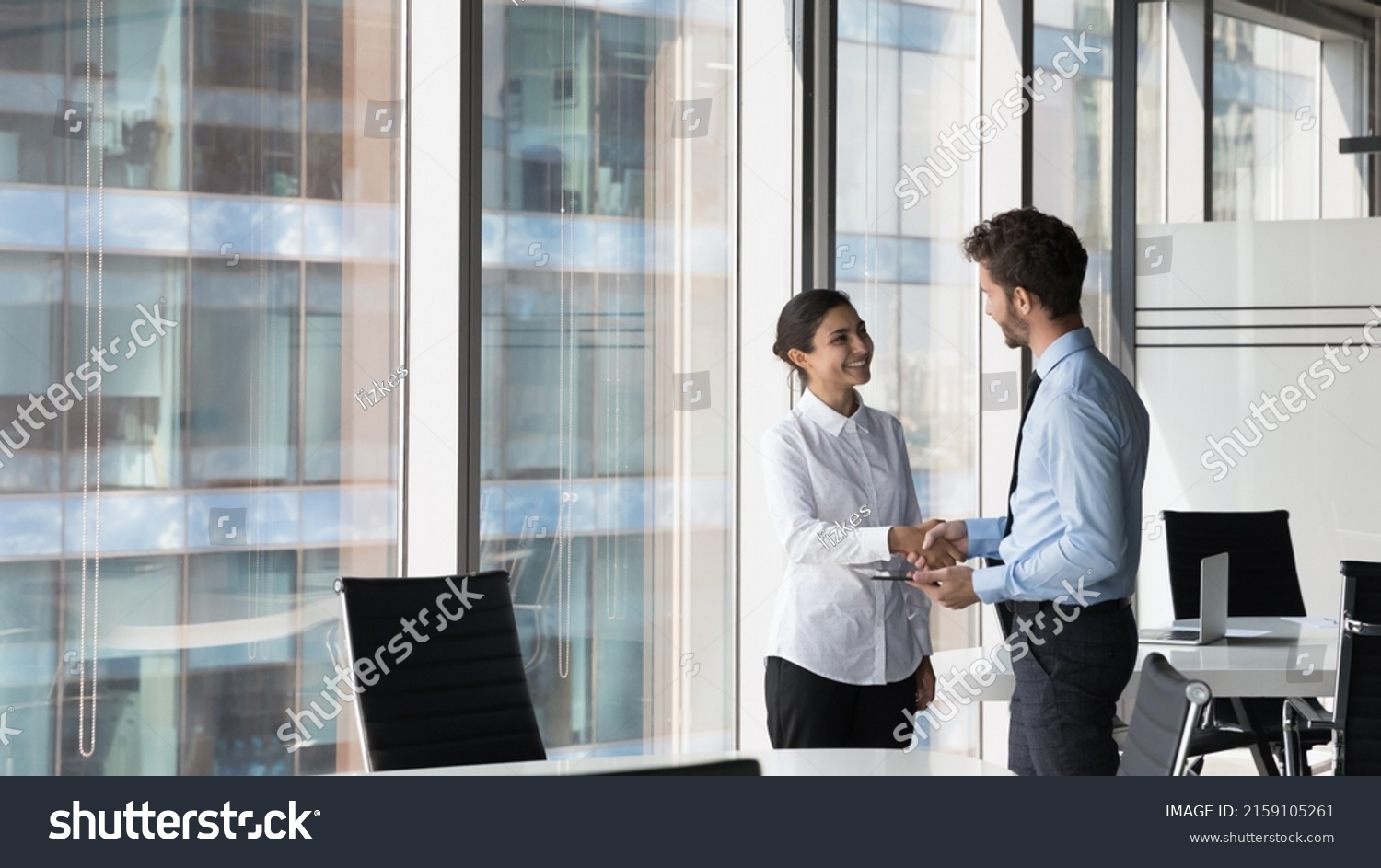 Indian woman shake hand company boss hr manager after successful job interview, client and manager handshake make deal feel satisfied. Multiracial workmates meet in office talk express respect concept #2159105261