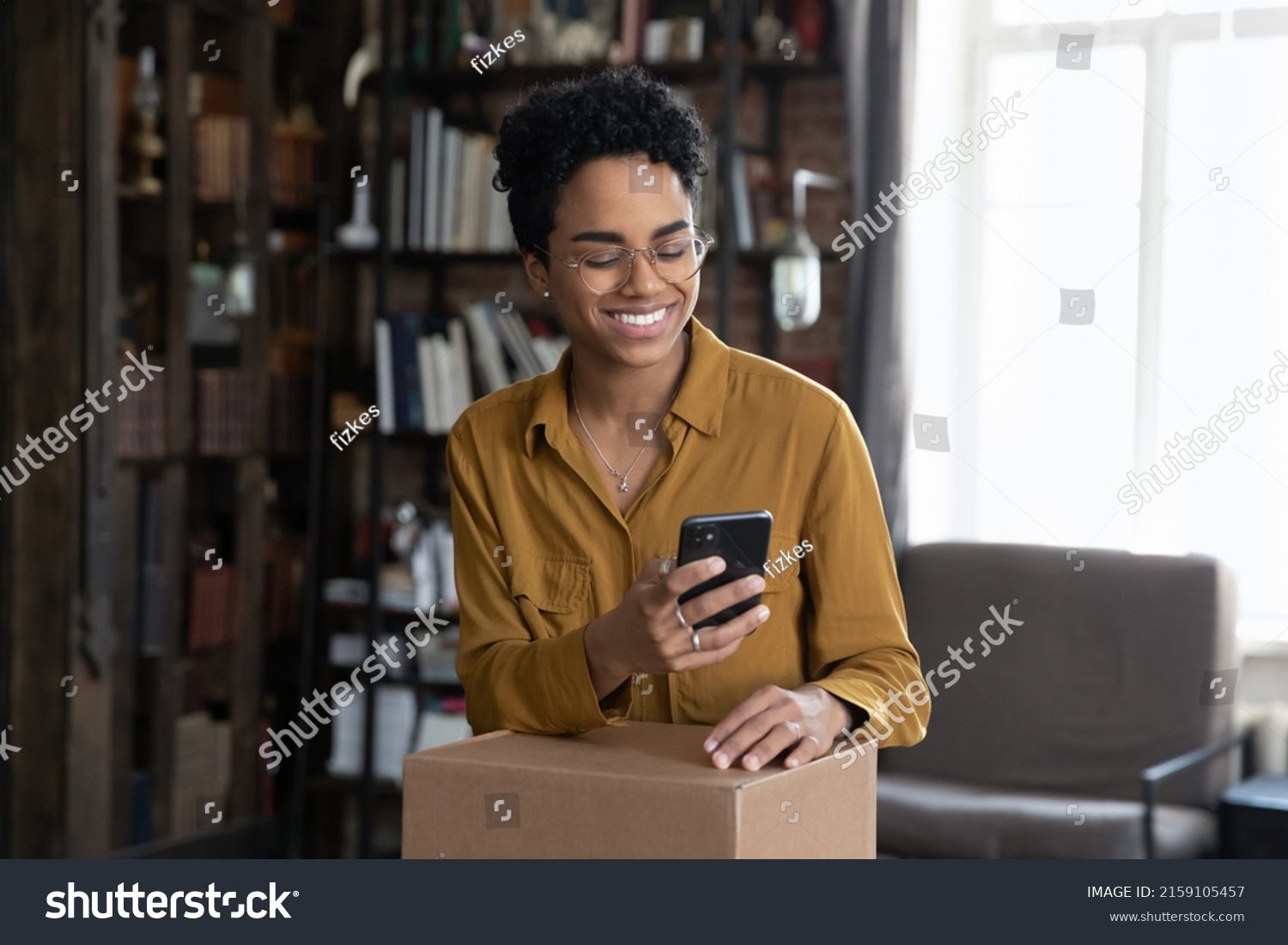 African woman client of easy trusted e-services online shipping, make order, use cellphone typing to courier, prepare parcel box for sending to friend abroad use reliable company of delivery services #2159105457