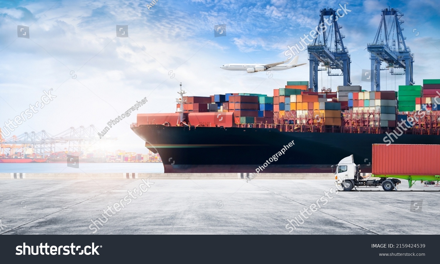 Container cargo freight ship during discharging at industrial port move to container yard by trucks, handlers, cargo plane, copy space, logistic import export background and transport industry concept #2159424539