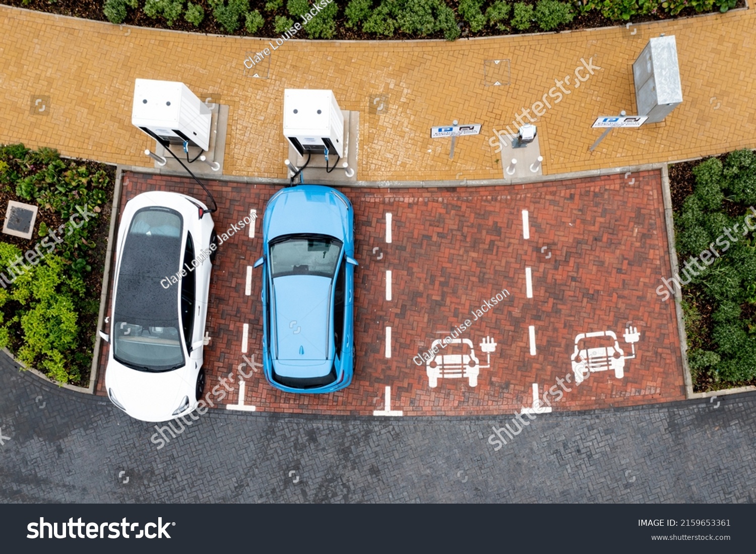 An aerial view directly above electric cars being charged at a motorway service station car charging station #2159653361