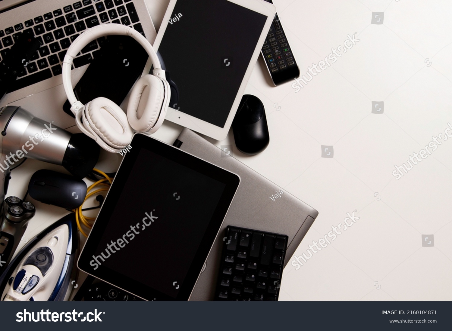 Old computers, digital tablets, mobile phones, many used electronic gadgets devices, broken household and appliances on white background. Planned obsolescence, electronic waste for recycling concept #2160104871