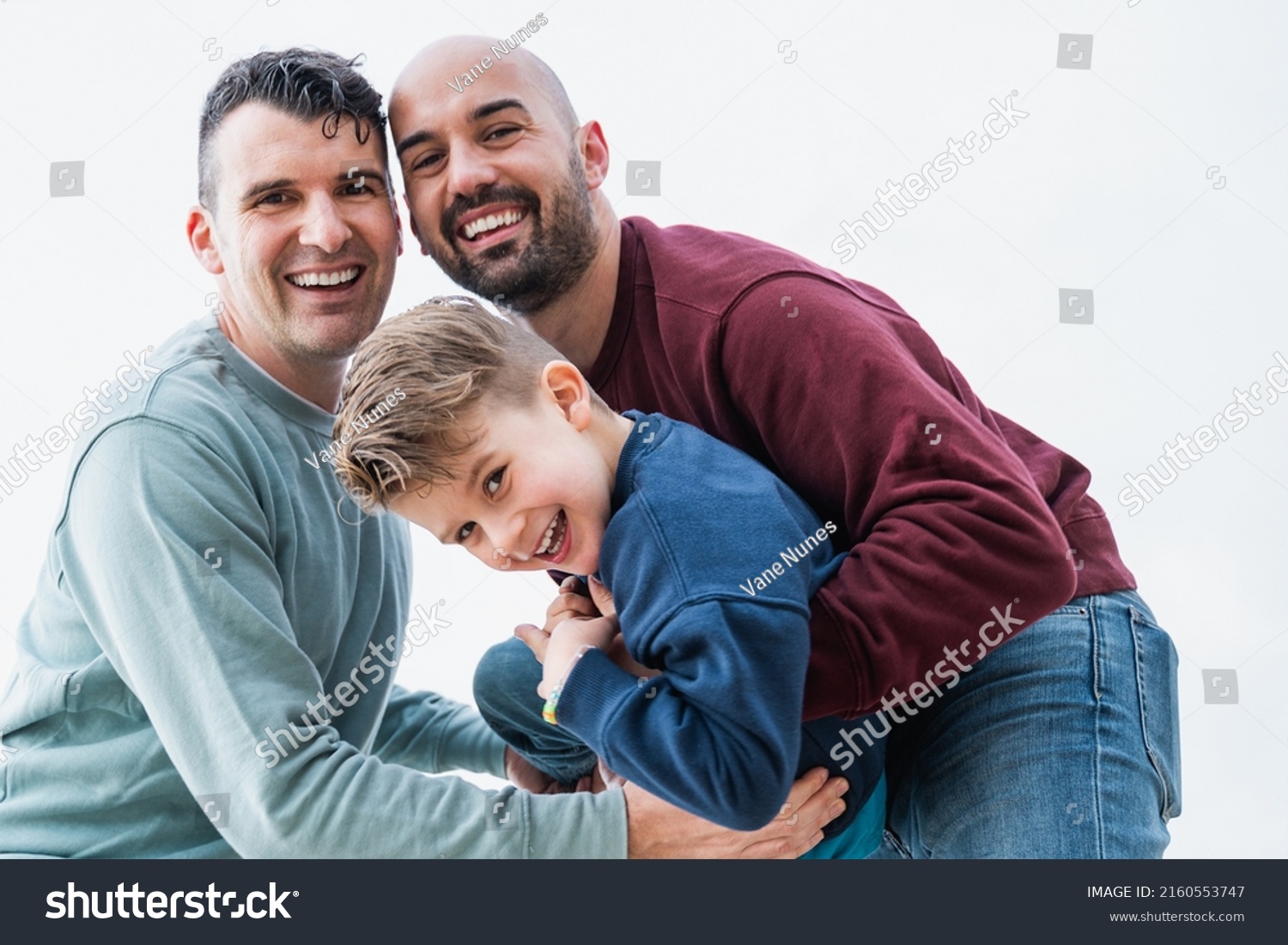 Gay fathers and son having fun together outdoor - LGBT diversity family love concept - Focus on left man face #2160553747