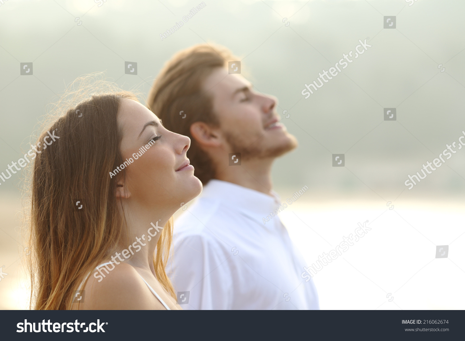 Profile of a couple of man and woman breathing deep fresh air together at sunset                #216062674