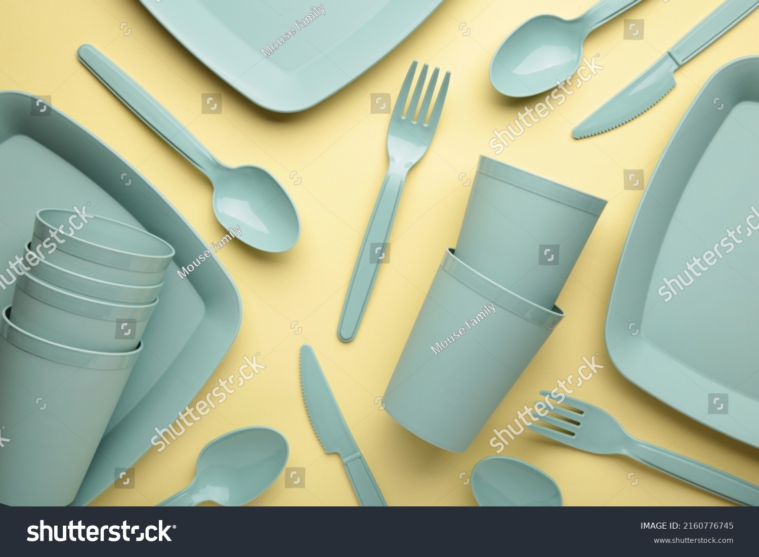 Bright plastic reusable tableware on a yellow background. Top view #2160776745