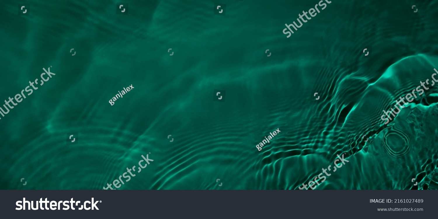 Transparent dark green clear water surface texture with ripples and splashes. Abstract summer banner background Water waves with copy space, top view. Cosmetic moisturizer micellar toner emulsion #2161027489