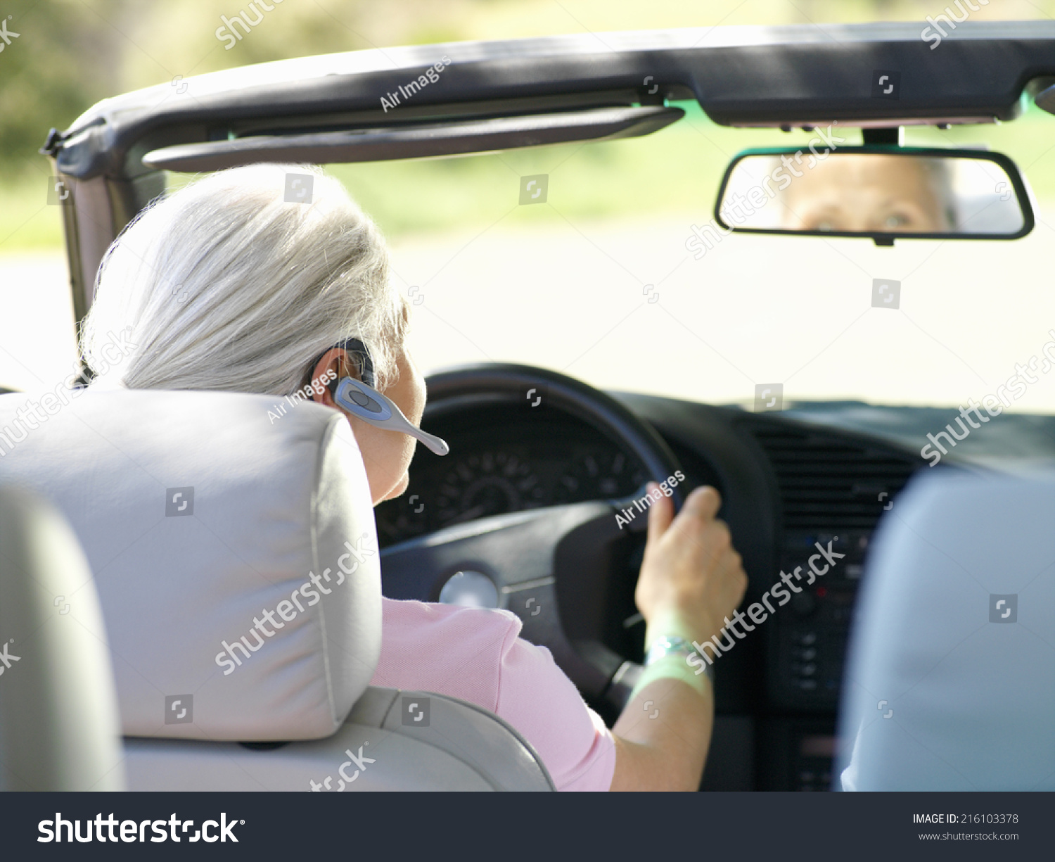 Woman with hands-free device in car, rear view #216103378