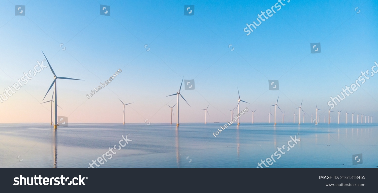 Windmill park in the ocean, drone aerial view of windmill turbines generating green energy electric, windmills isolated at sea in the Netherlands. High quality 4k footage #2161318465
