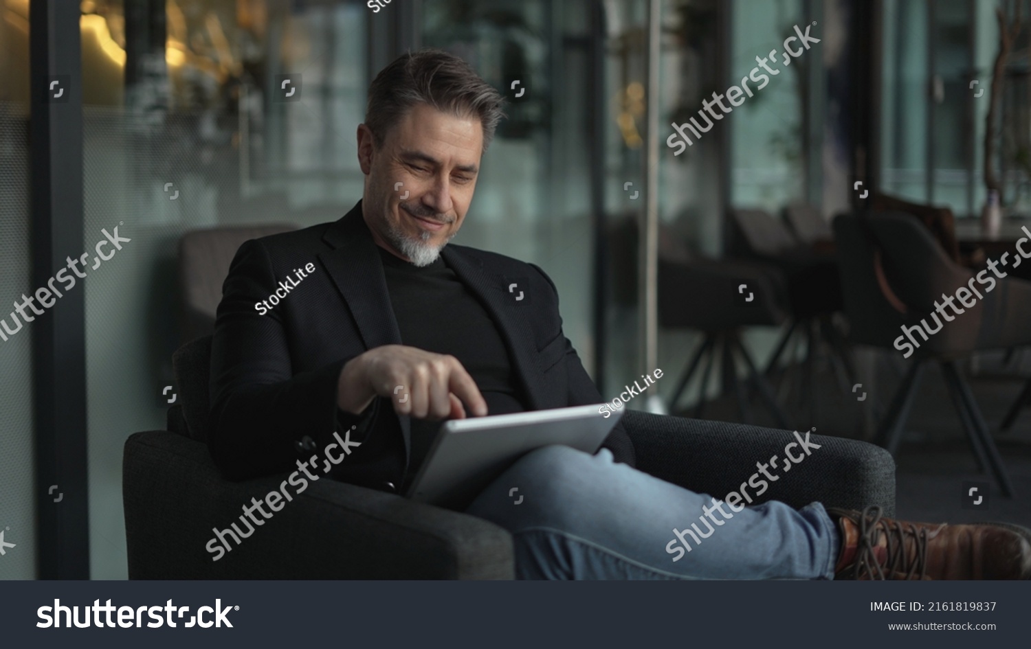 Businessman using tablet computer in office. Happy middle aged man in business casual, Entrepreneur working online, reading finance report, thinking. #2161819837