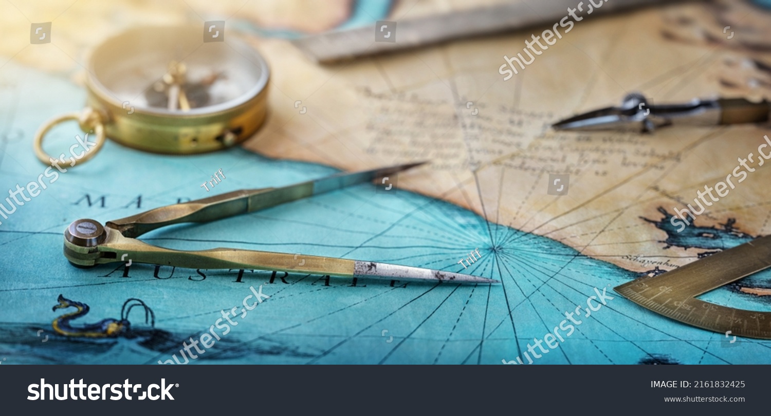 An old geographic map with navigational tools: compass, divider, ruler, protractor. View of the workplace of ship's captain. Travel, geography, navigation, tourism and exploration concept background. #2161832425