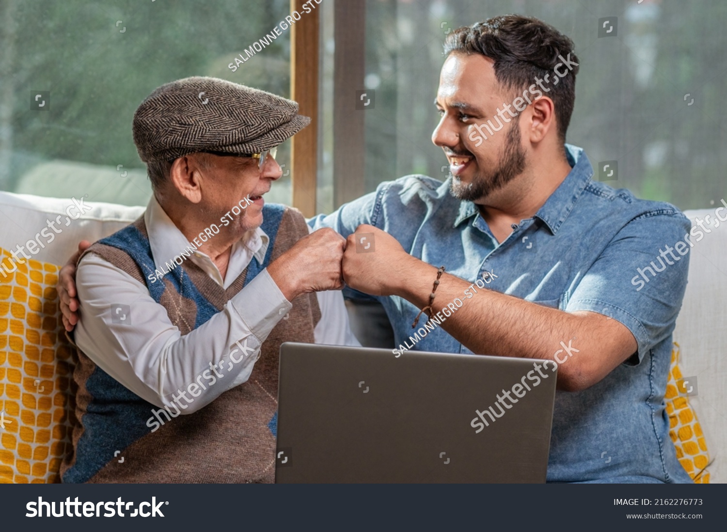 Happy adult senior father with his adult son. Young man enjoys teaching his older father how to use a laptop. How to use technology. #2162276773
