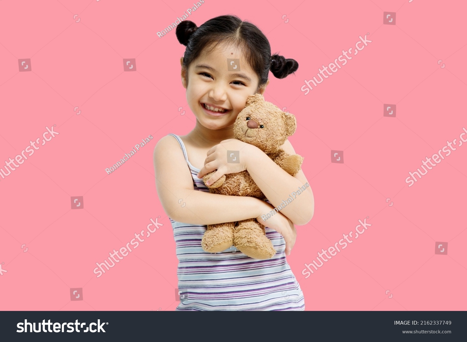 Asian cute little Asian child girl hugging teddy bear isolated on pink background. #2162337749