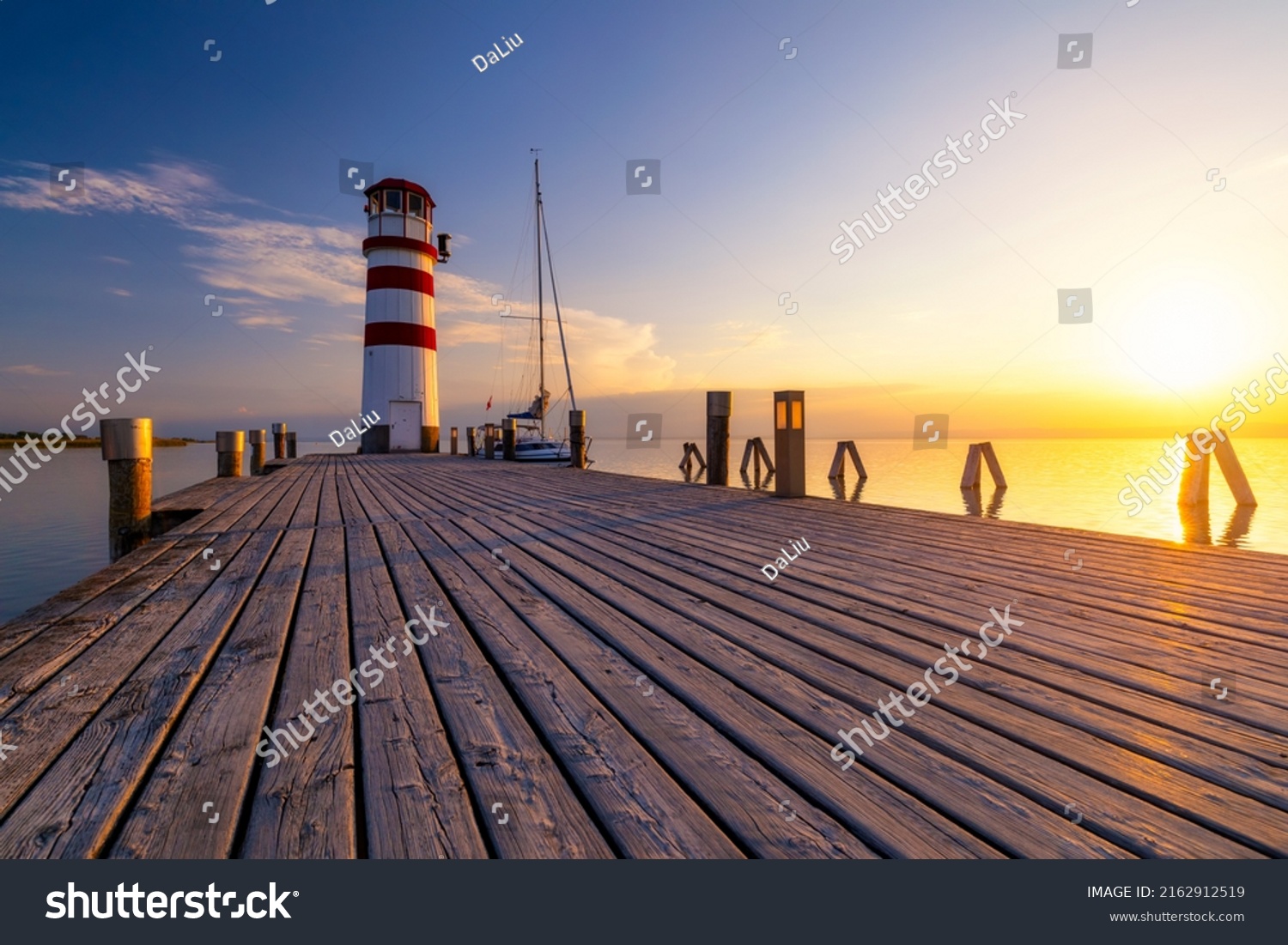 Lighthouse at Lake Neusiedl, Podersdorf am See, Burgenland, Austria. Lighthouse at sunset in Austria. Wooden pier with lighthouse in Podersdorf on lake Neusiedl in Austria. #2162912519