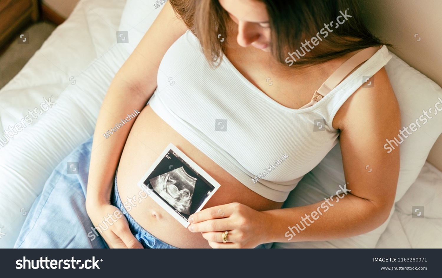 Ultrasound photo pregnancy baby. Woman holding ultrasound pregnant picture. Concept maternity, pregnancy, childbirth #2163280971