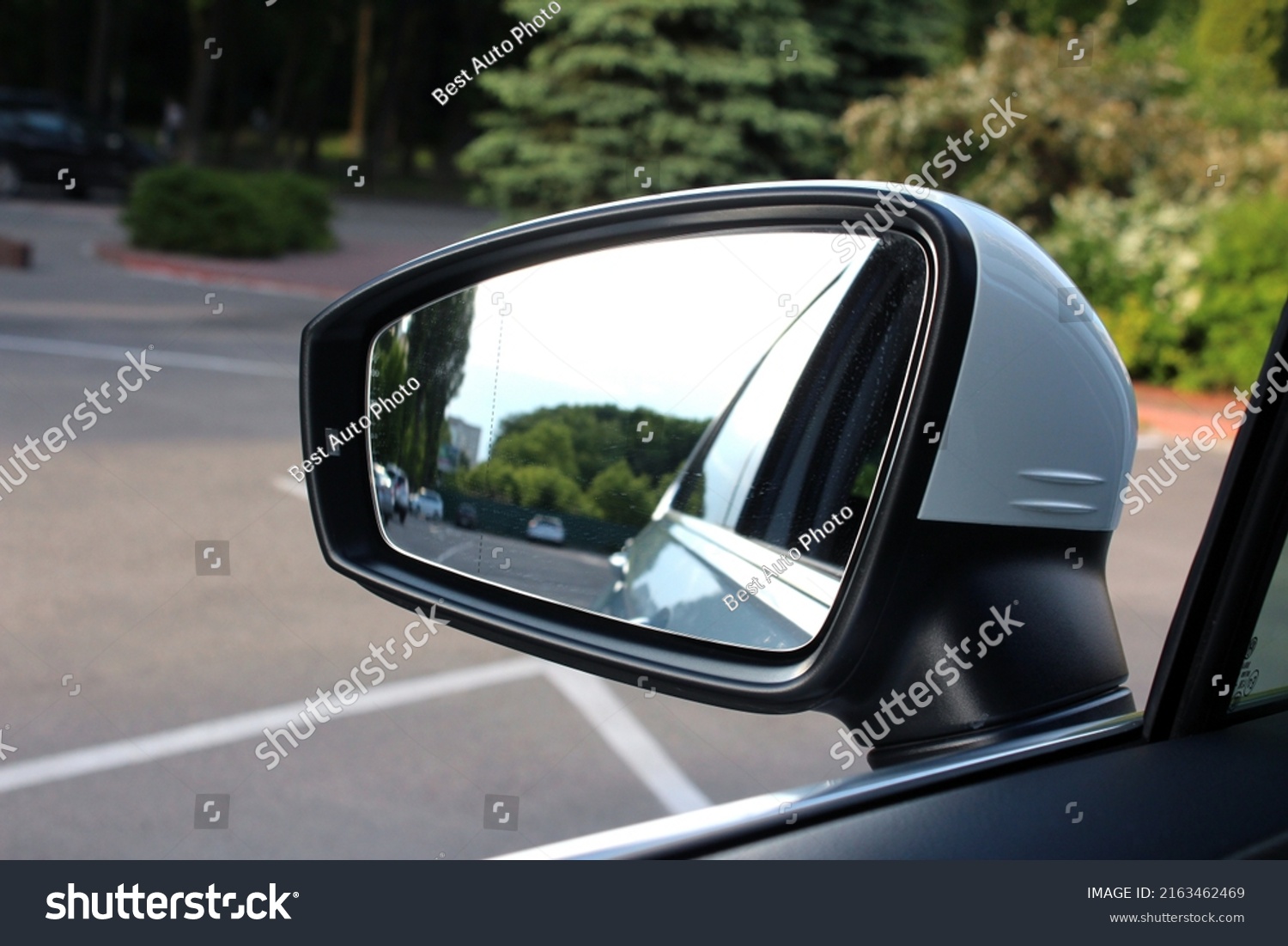 Rear view mirror car on the road. Rearview mirror with reflection in it. Accessory for vehicles to look back on road for good visibility and drive car safely. Wing mirror of a Car with nature street. #2163462469