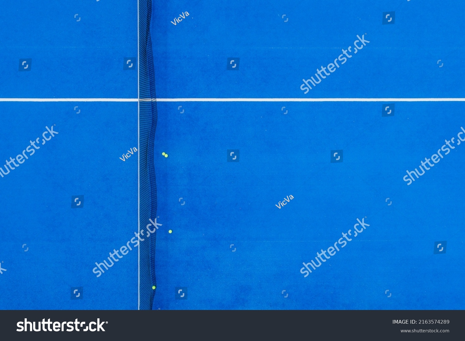 aerial view of a paddle tennis court with four balls near the net #2163574289