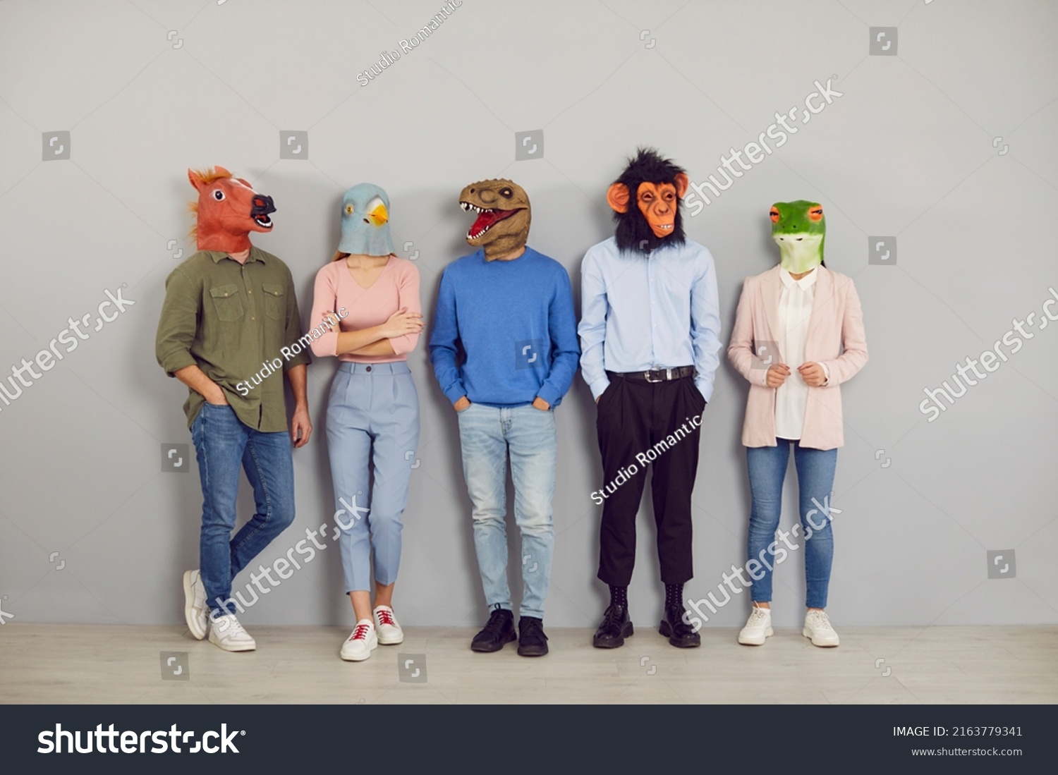 Funny half people half animals waiting by office wall together. Group portrait company workers, students or job applicants wearing extravagant wacky absurd comedy fancy dress carnival masquerade masks #2163779341