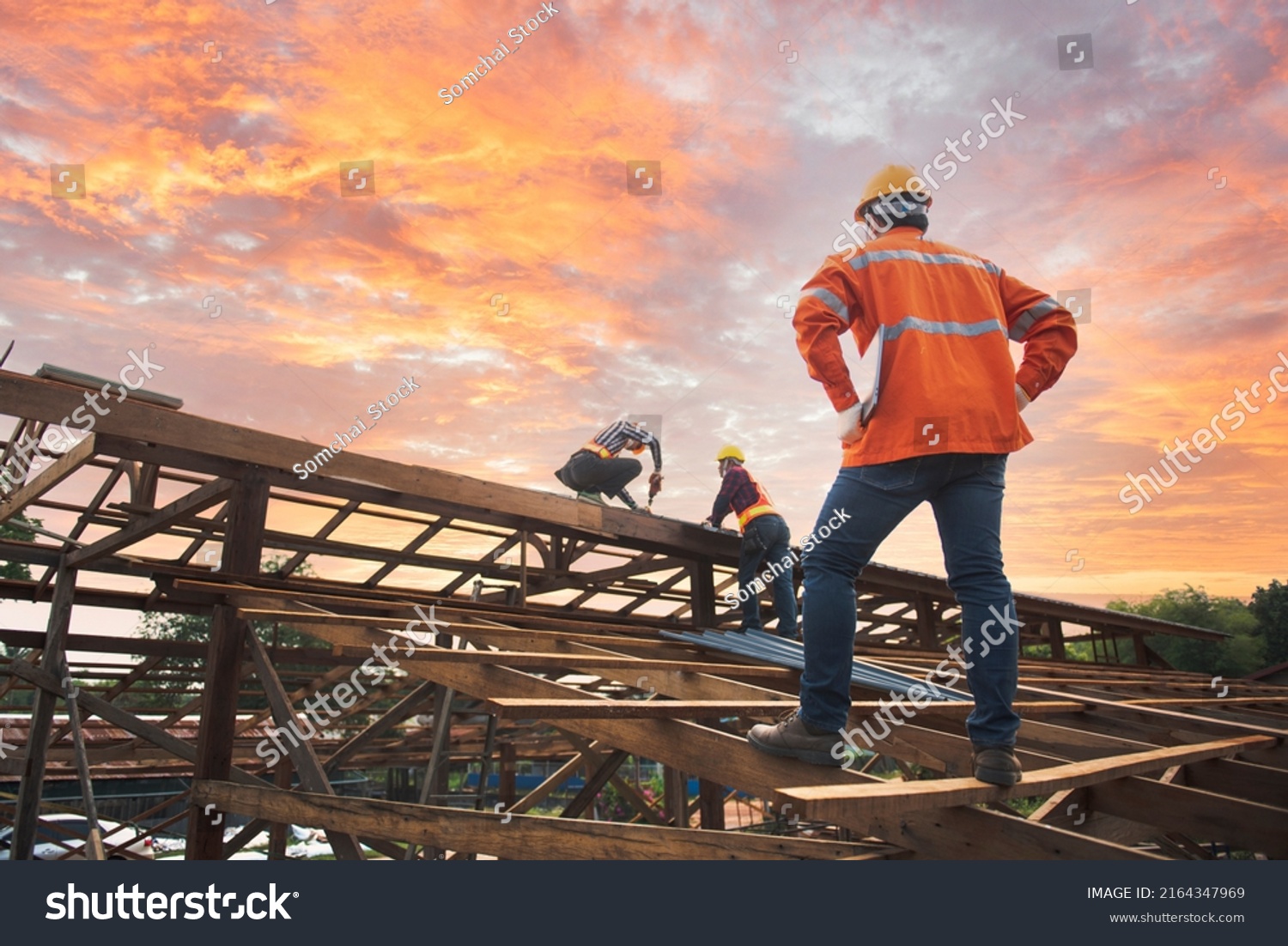 Engineer inspects, installers, repairs roofs above the clouds, blue sky, technicians install roofing at the top of the house, renovate, renovate, build a country house #2164347969