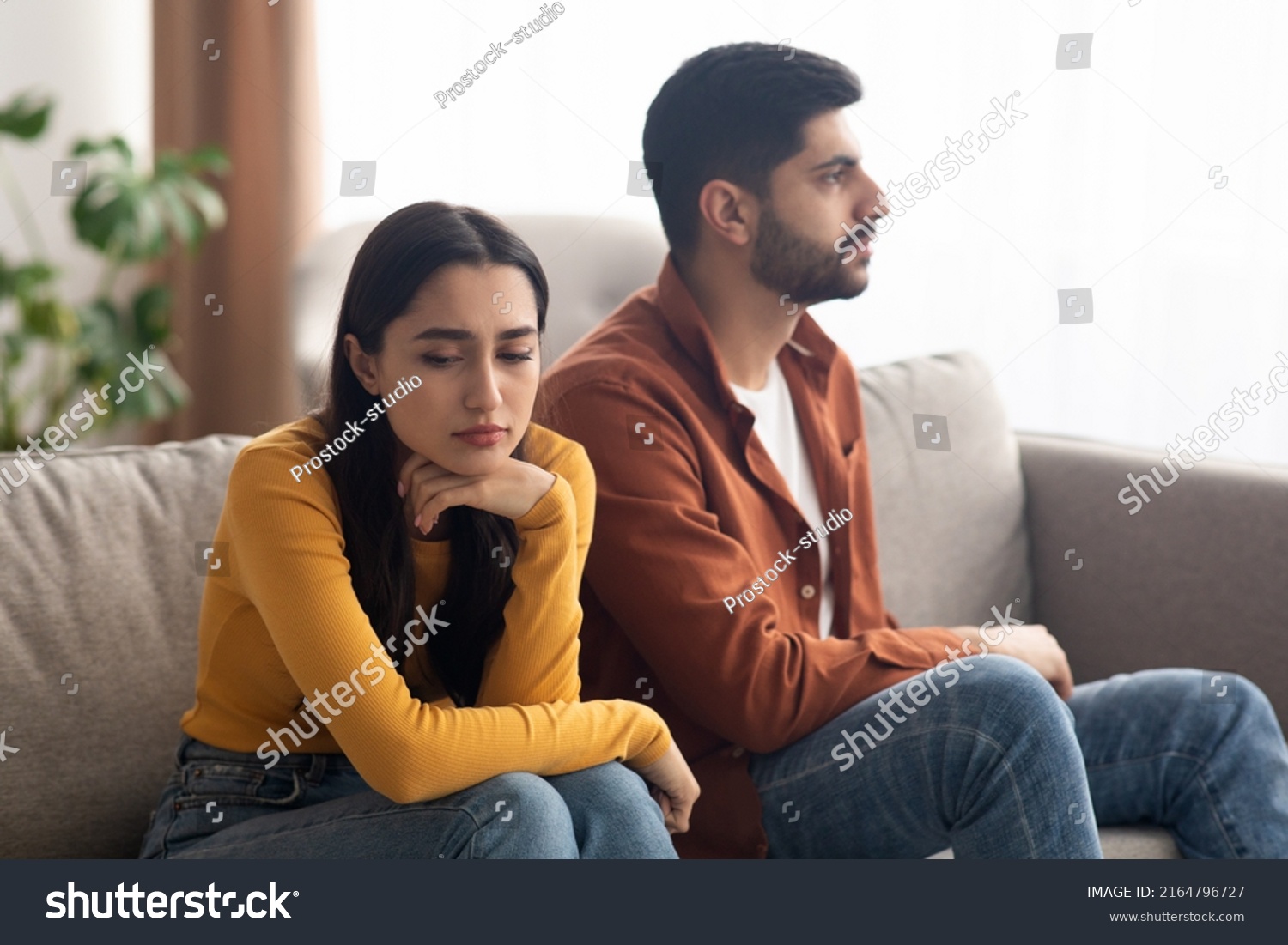 Marital Crisis. Unhappy Arabic Couple Sitting On Couch At Home, Having Relationship Problems. Bad Marriage, Breakup Concept. Selective Focus On Frustrated Woman #2164796727