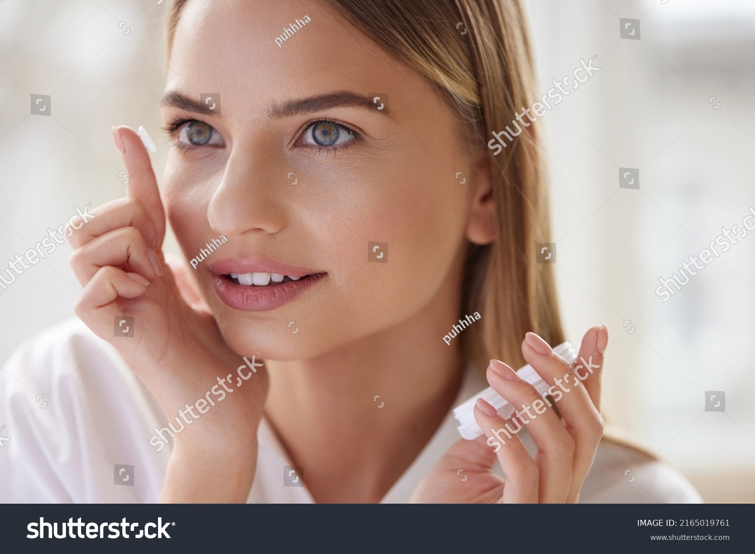 Eye care. Smiling Woman With Contact Eye Lens on Finger Closeup. Portrait of Beautiful Blonde Girl Putting Contacts Lenses in Eyes. Vision Health Concept  #2165019761