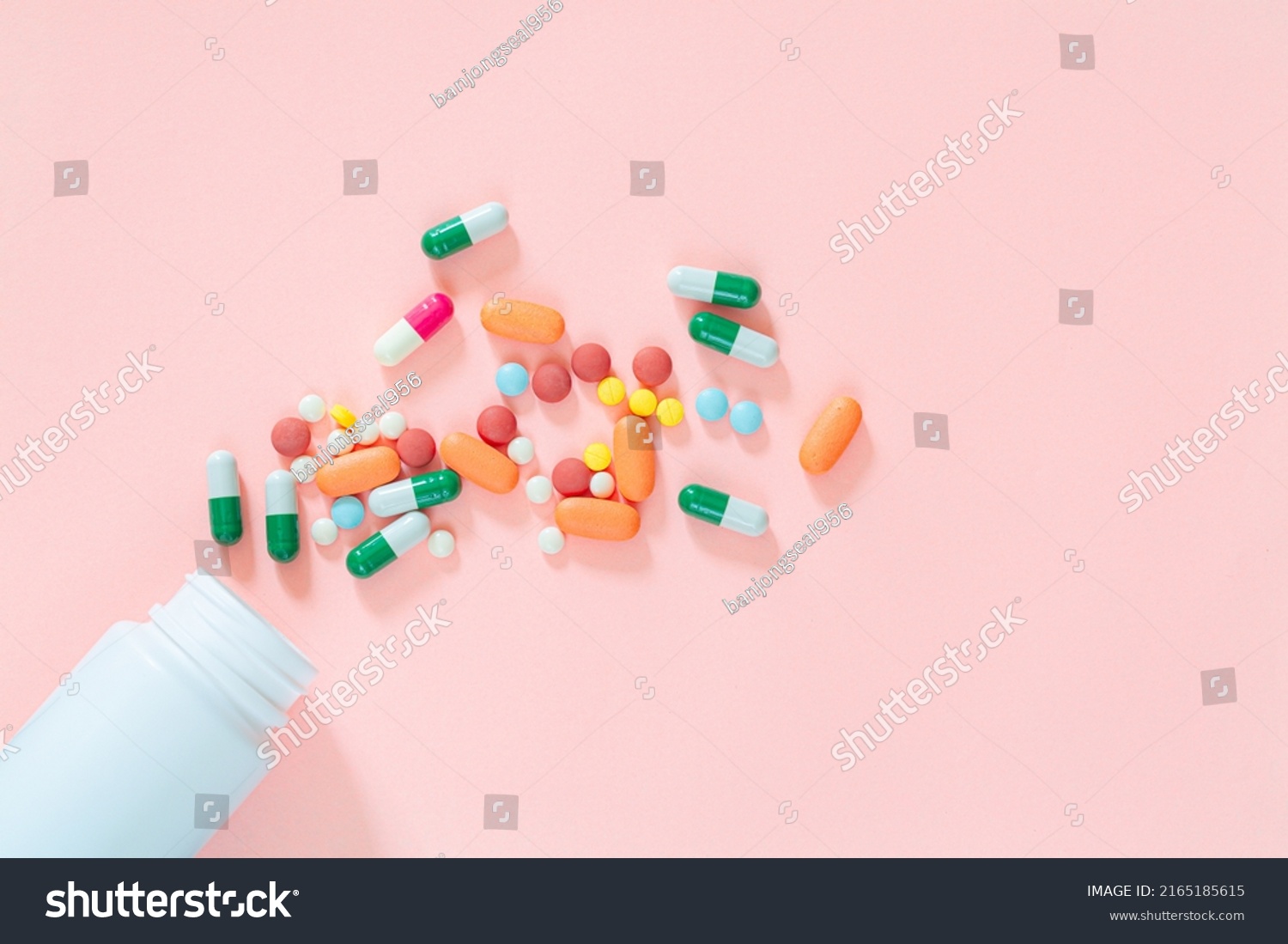 pills and pill bottles on pink background,Assorted pharmaceutical medicine pills, tablets and capsules and bottle on pink background. Top view. Flat lay. Copy space. Medicine concept. Heap of pills on #2165185615