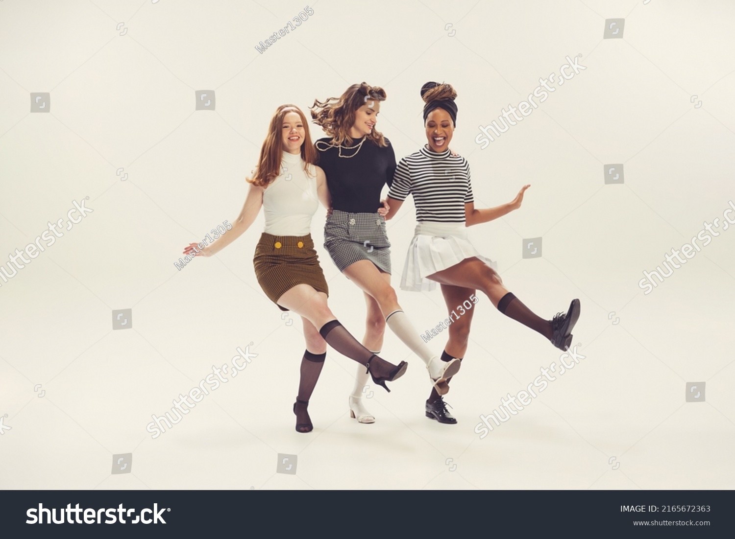 Dancing. Pretty young girls in retro 80s, 90s fashion style, outfits isolated over white studio background. Concept of eras comparison, beauty, fashion and youth. Look happy, excited, delighted #2165672363