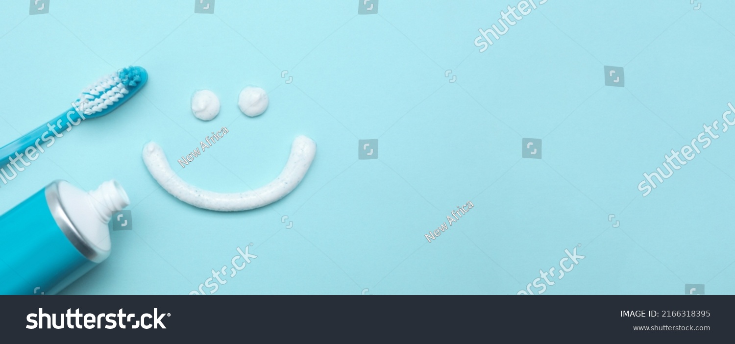 Smiling face made of toothpaste, brush and tube on light blue background, flat lay with space for text. Banner design #2166318395