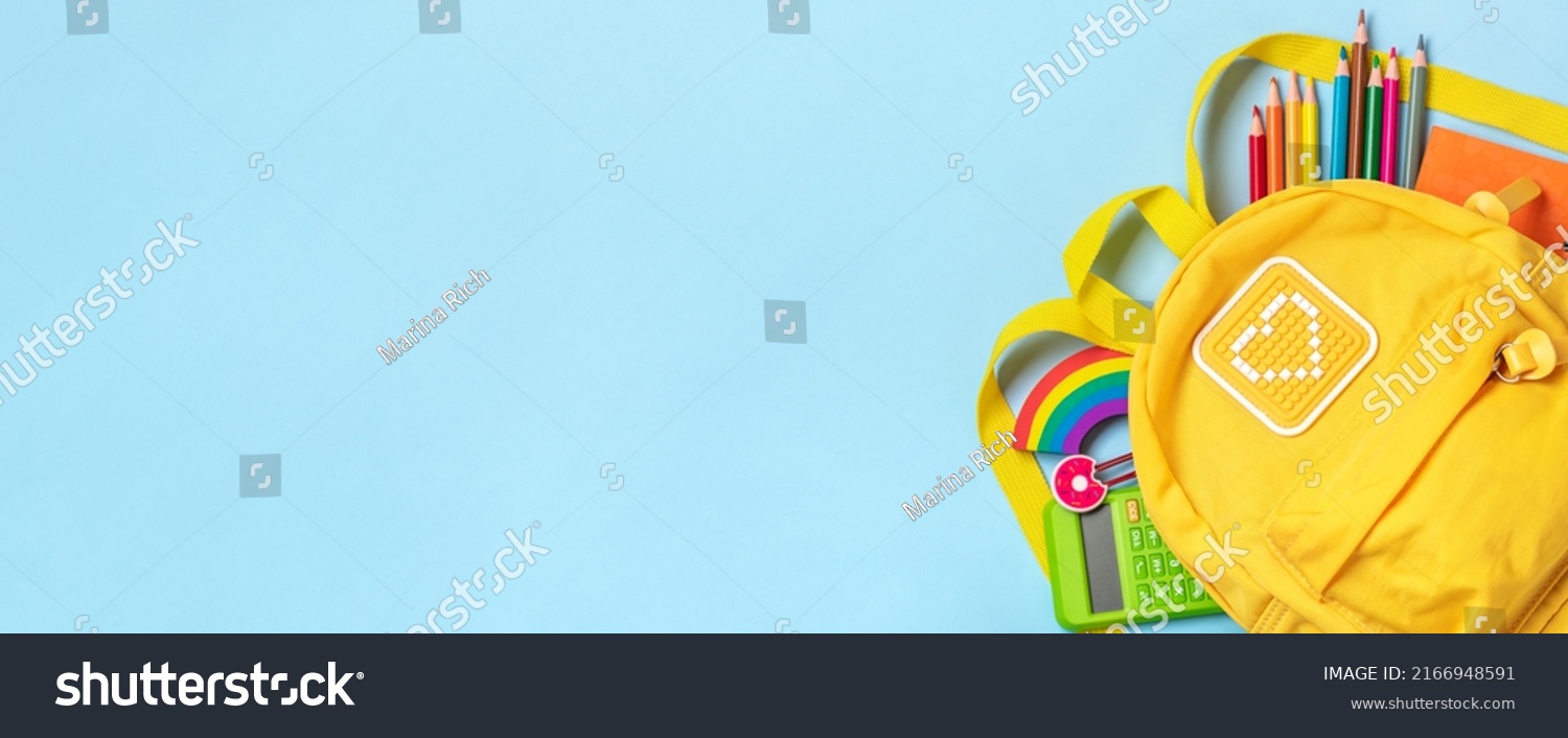Back to school, education concept Yellow backpack with school supplies - notebook, pens, eraser rainbow, numbers isolated on blue background Top view Copy space Flat lay composition Banner #2166948591