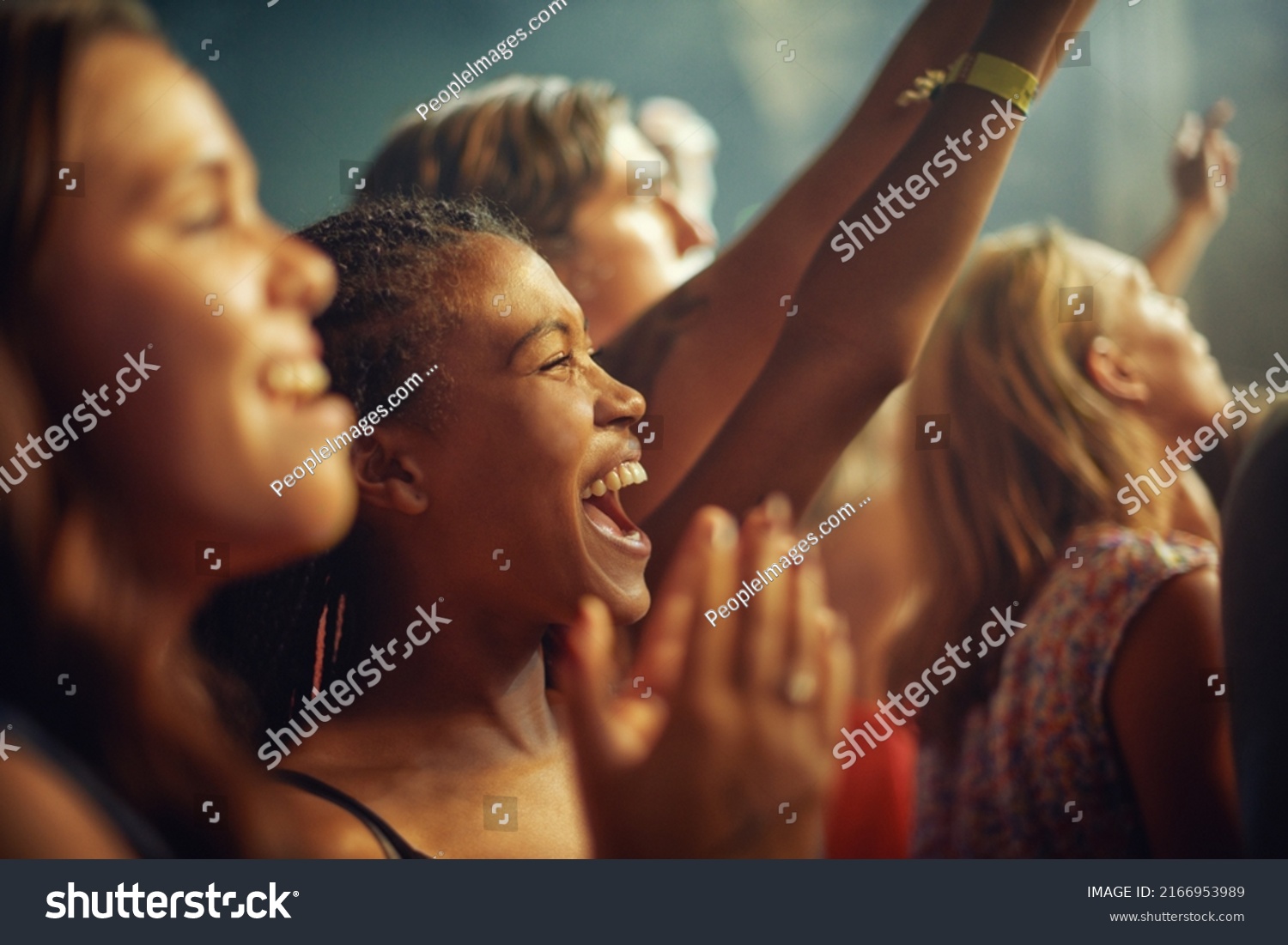 Having the time of their lives. Young girls in an audience enjoying their favourite bands performance. #2166953989