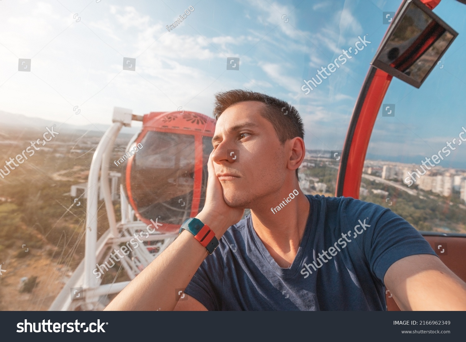 Depressed and sad young man taking selfie while riding ferris wheel in amusement luna park. Loneliness and depression concept #2166962349