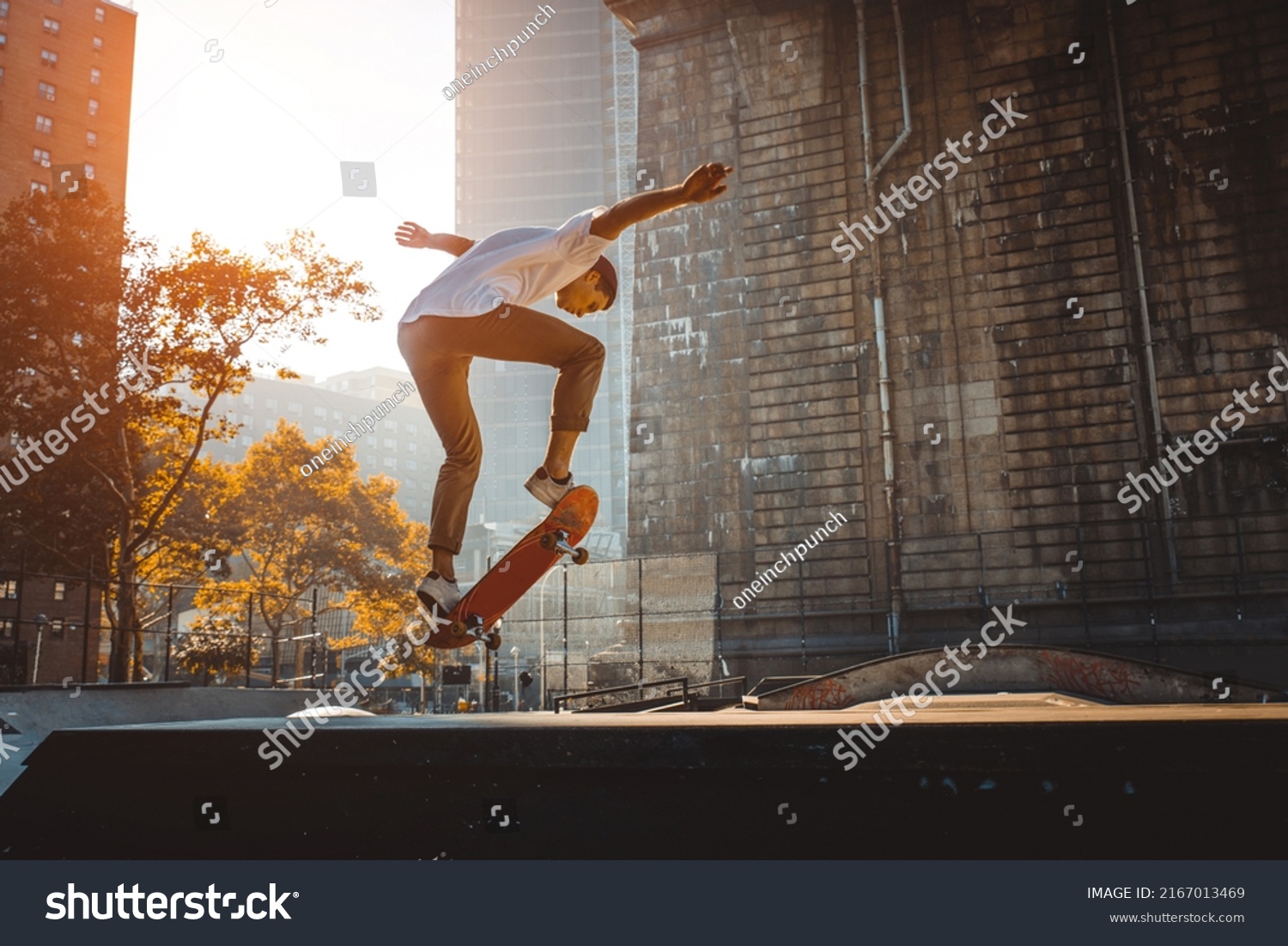 Young adult skating outdoors - Stylish skateboarder boy training in a nNew York skate park, concepts about sport and ifestyle #2167013469