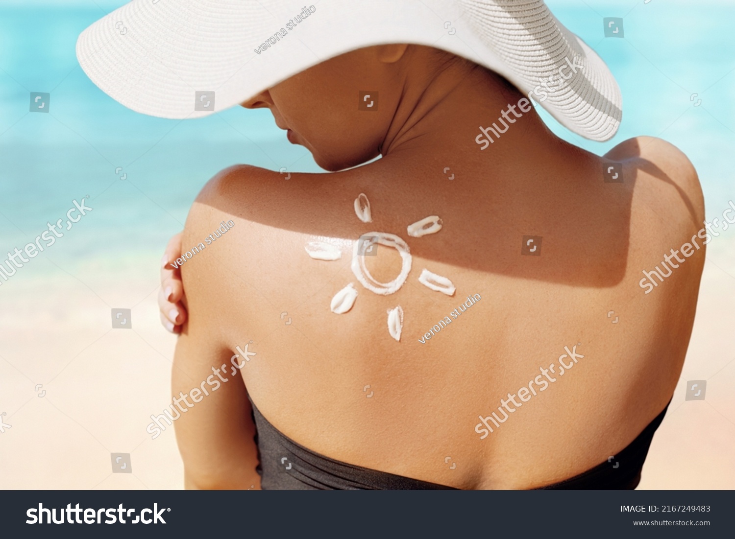 Sun Protection. Beauty Woman Applying Sun Cream Creme on Tanned  Shoulder In Form Of The Sun. . Skin Care. Girl Using Sunscreen to Skin. #2167249483