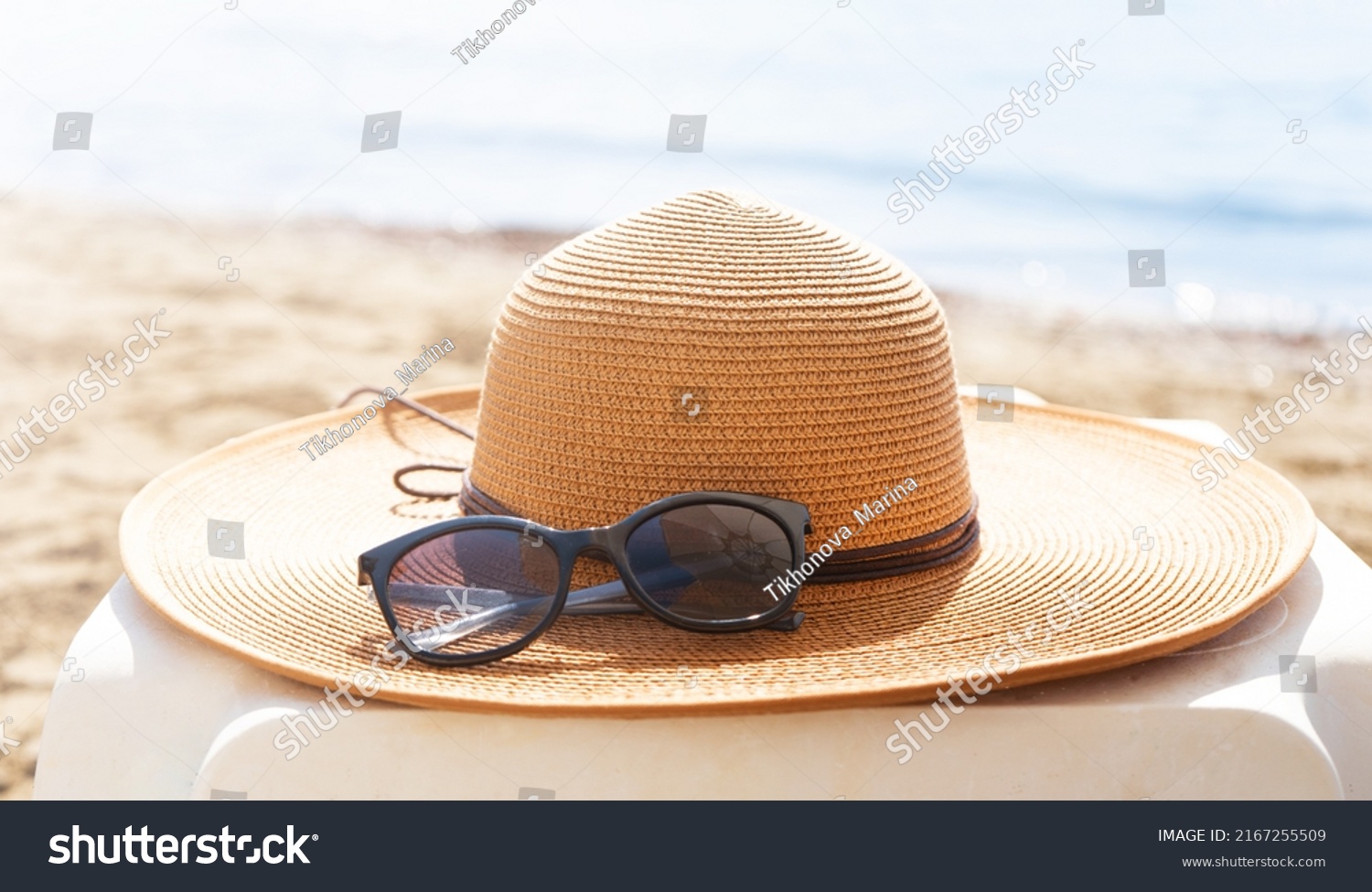 Straw hat and sunglasses on the beach. Beach holiday concept.  #2167255509