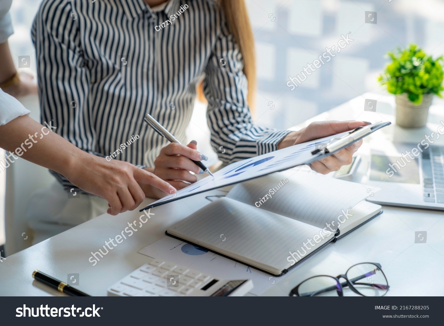 Analysis, Discussion, Asian woman economist and marketer pointing to a financial data sheet to plan, Negotiation #2167288205