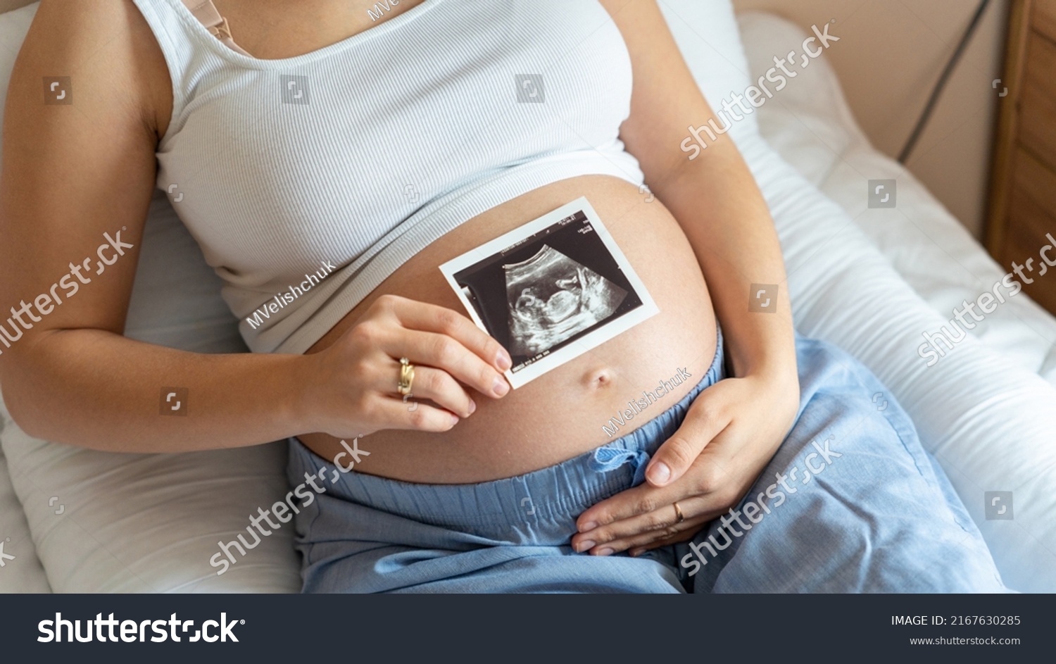 Ultrasound picture pregnant baby photo. Woman holding ultrasound pregnancy image. Concept of pregnancy, maternity, expectation for baby birth #2167630285