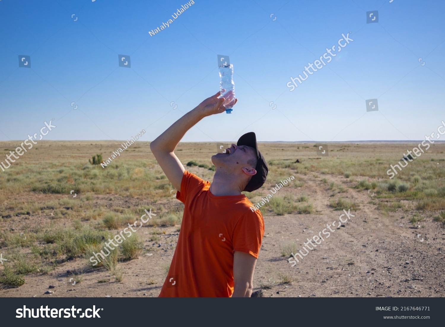 a man with an empty bottle in the desert. thirst. danger of dehydration. out of water #2167646771
