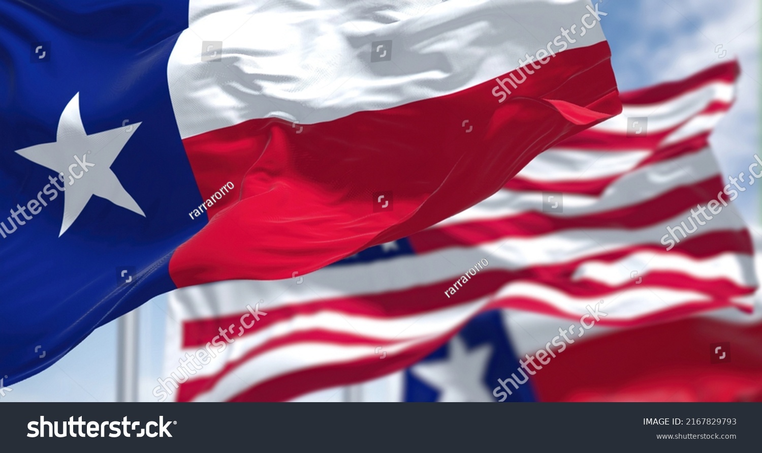 The Texas state flag waving along with the national flag of the United States of America. Texas s a state in the South Central region of the United States #2167829793