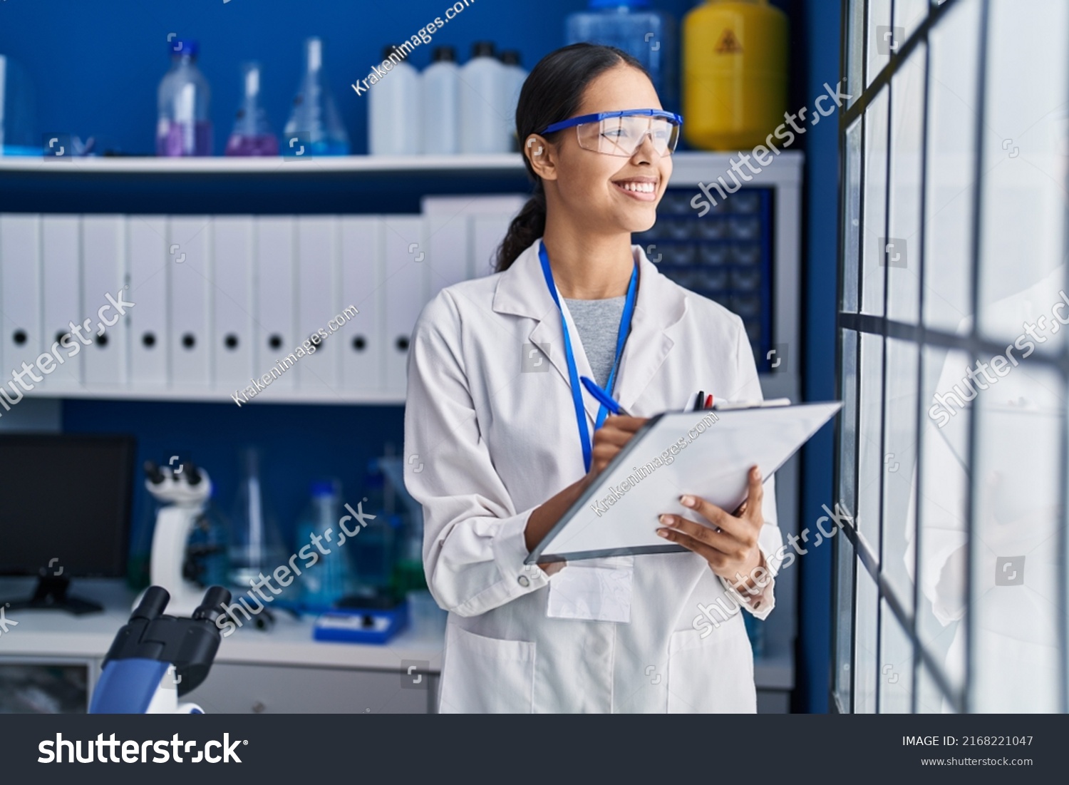 Young african american woman scientist write on report document at laboratory #2168221047