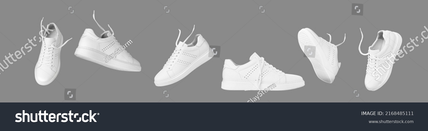 Flying white leather sneakers isolated on gray background. Fashionable stylish sports casual shoes. Creative minimalistic layout with footwear. Advertising for shoe store, blog #2168485111