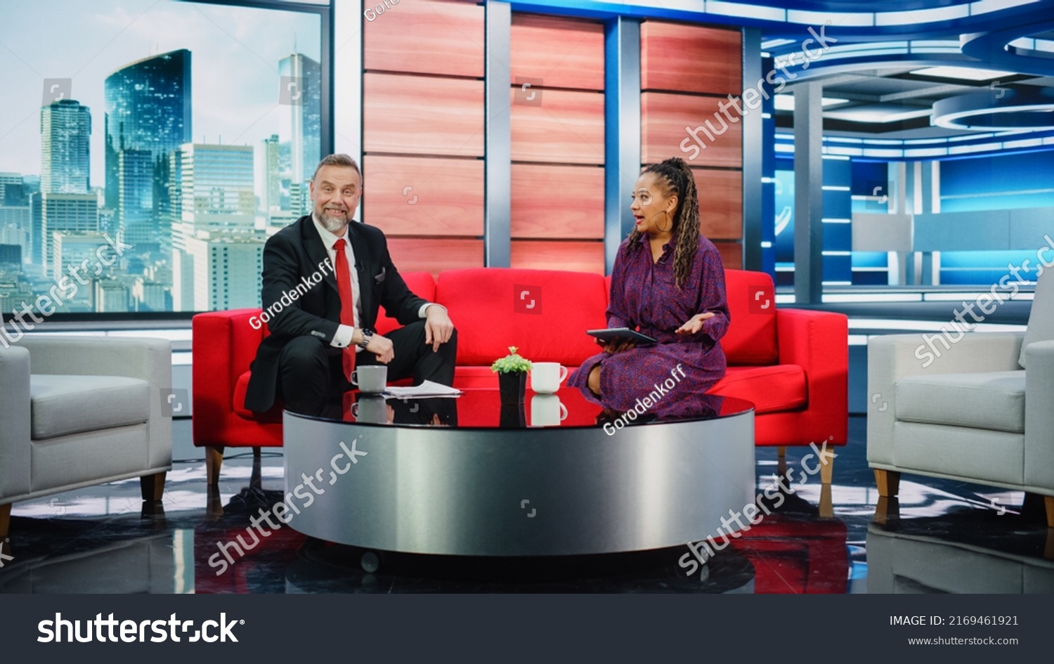 Talk Show TV Program and News Discussion: Two Charismatic Presenters Talk, Have Fun. Cable Channel Hosts Have Friendly Conversation. Morning, Breakfast Television Entertainment in Studio Concept #2169461921