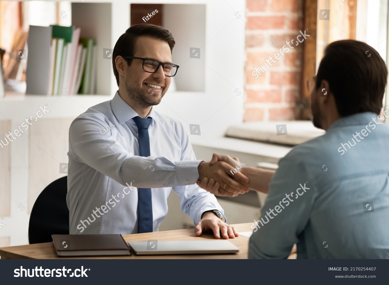HR manager handshakes company position candidate, selling insurance, professional services. Male entrepreneurs, broker and client shake hands start business meeting in office. Job interview concept #2170254407
