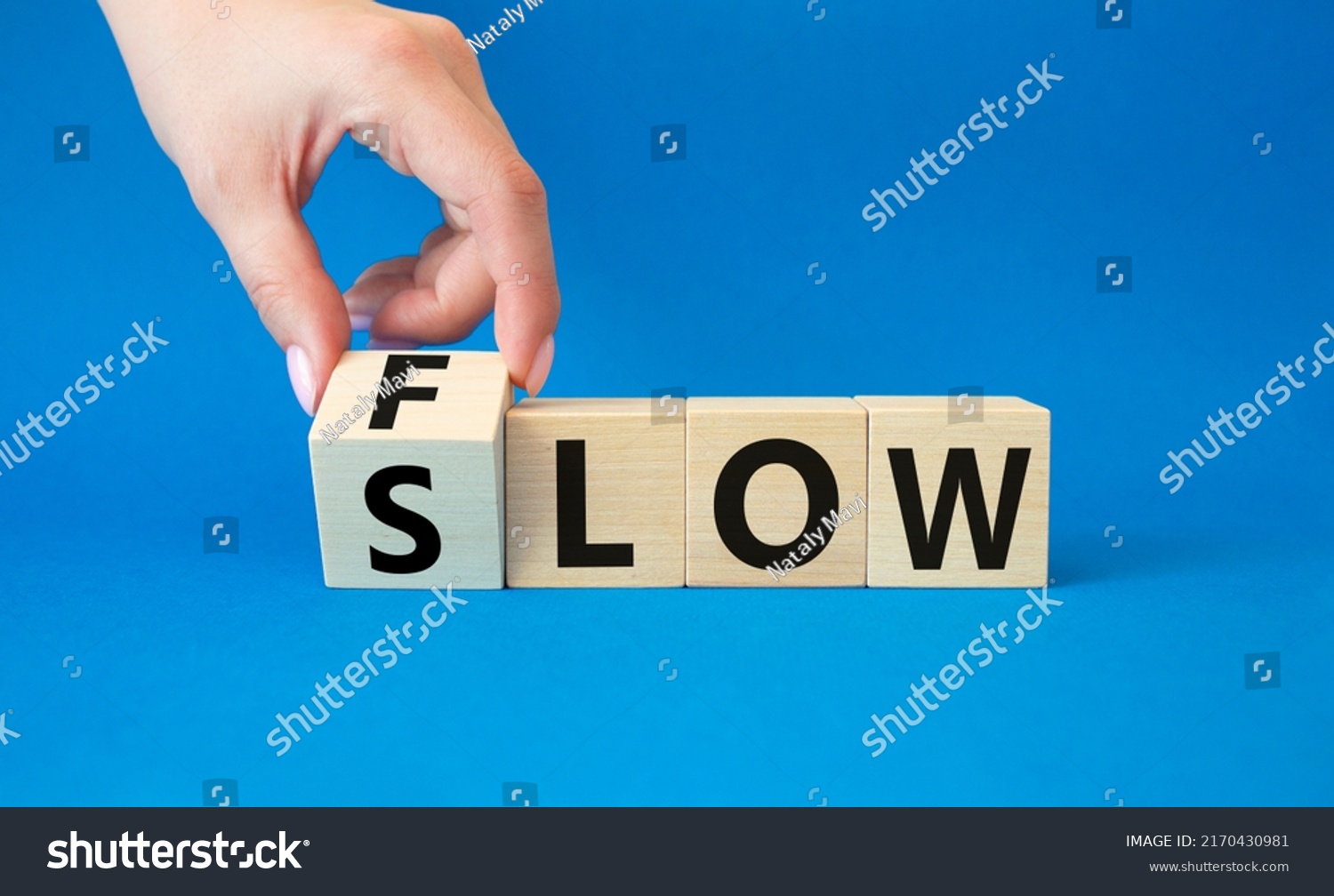 Flow and Slow symbol. Concept words Flow and Slow on wooden cubes. Beautiful blue background. Businessman hand. Business and Flow and Slow concept. Copy space. #2170430981