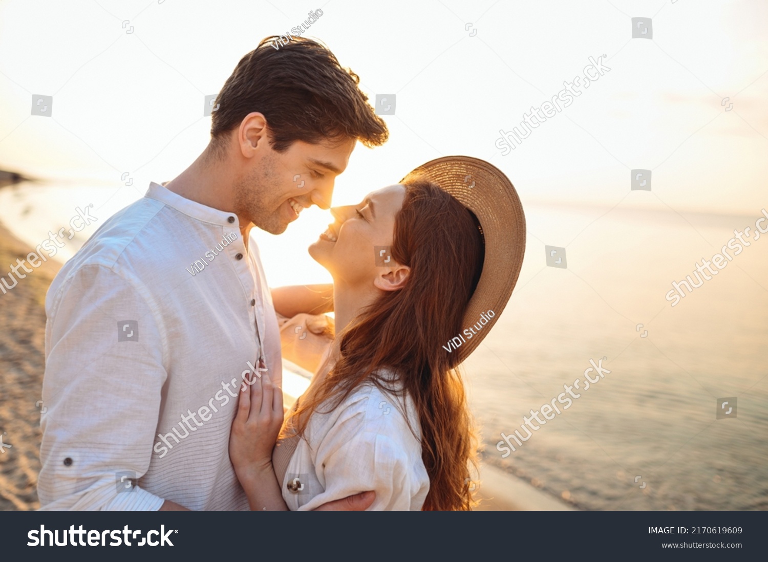 Close up profile young happy couple two friends family man woman in white clothes hug touch noses going to kiss together at sunrise over sea beach ocean outdoor seaside in summer day sunset evening. #2170619609