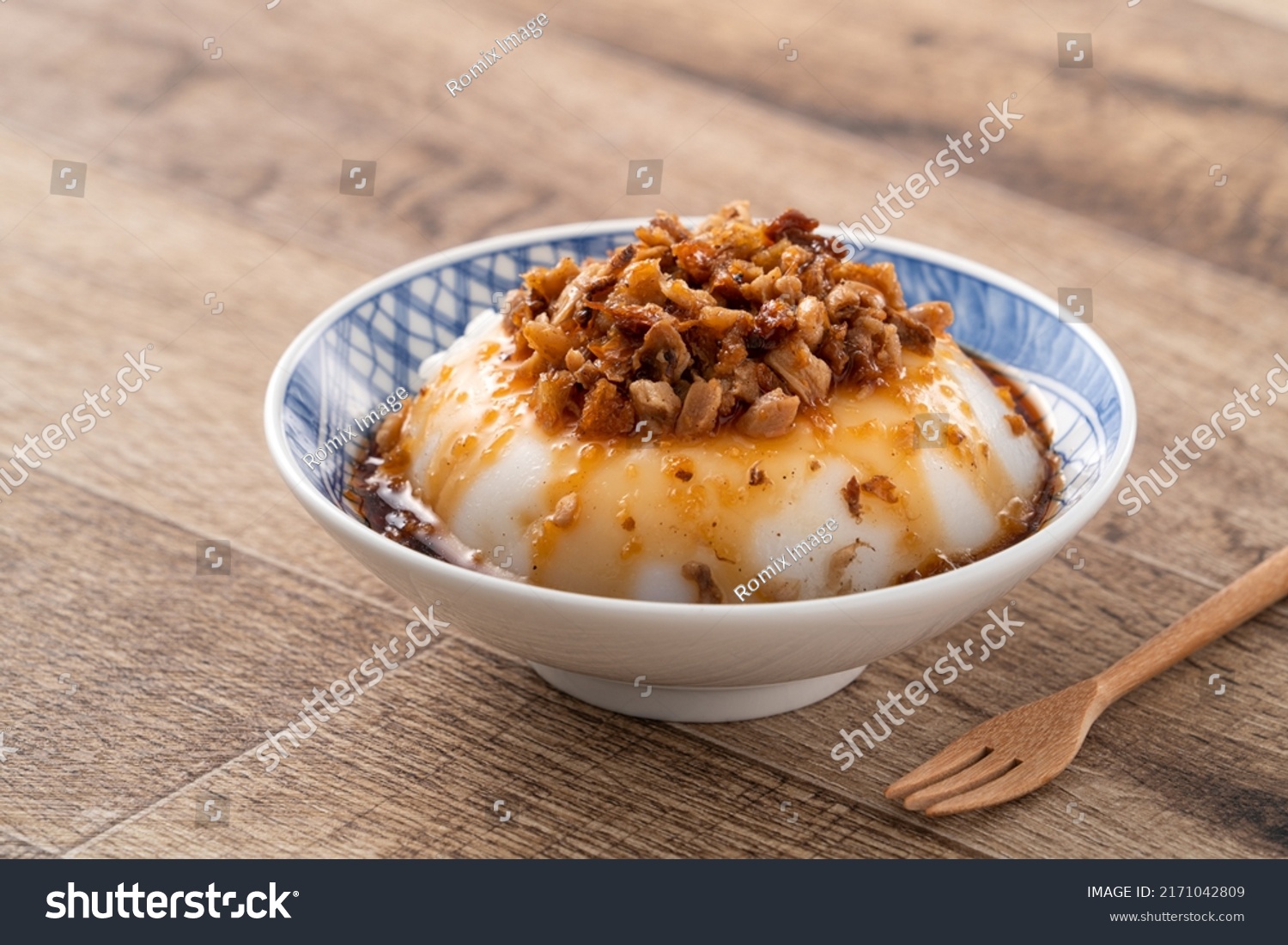 Taiwanese savory rice pudding Wa gui, rice cake with chopped dried radish topping and soy sauce in a bowl. #2171042809