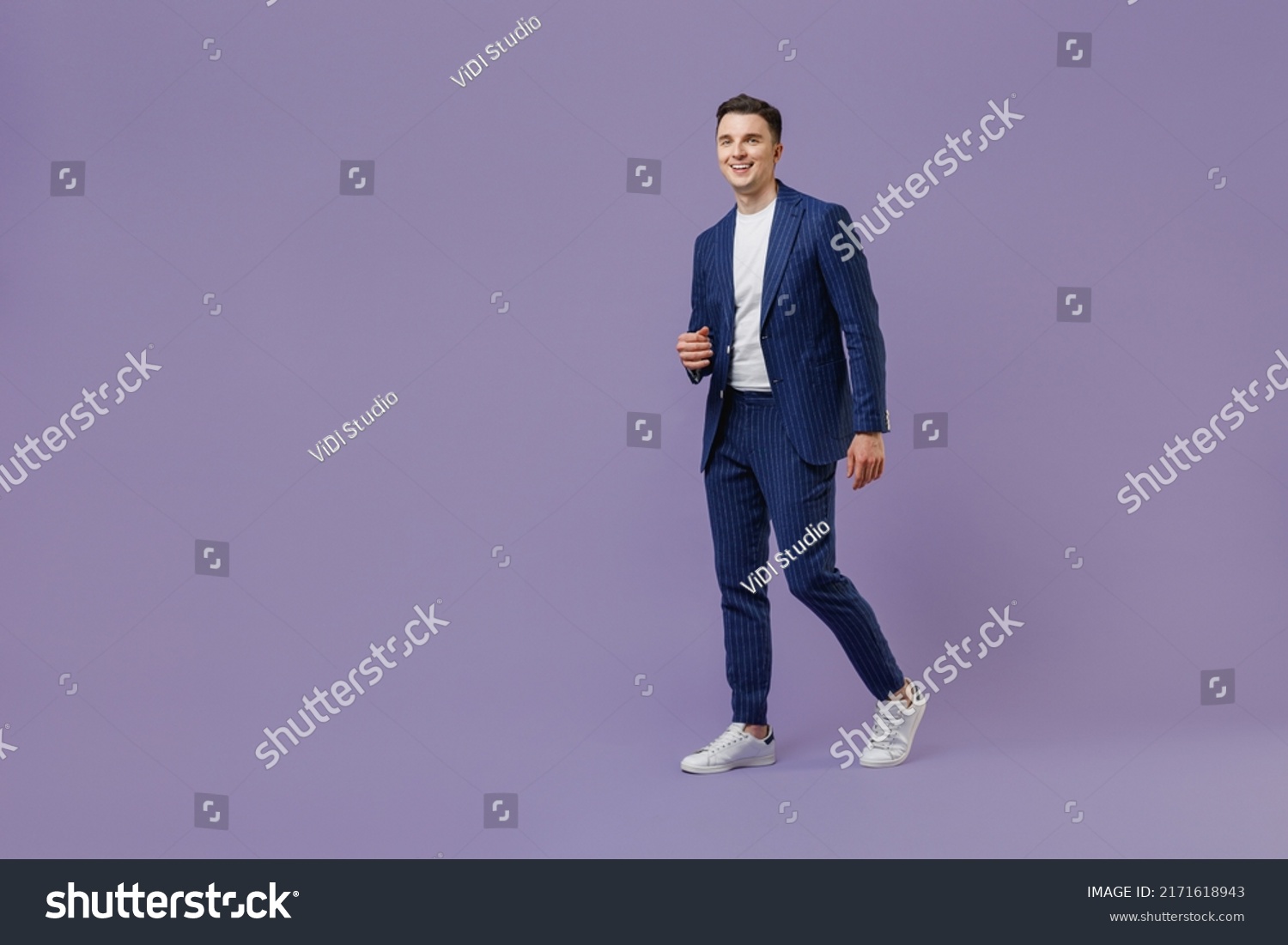 Full size body length young successful employee business man lawyer 20s wear formal blue suit white t-shirt work in office move stroll look aside isolated on pastel purple background studio portrait #2171618943