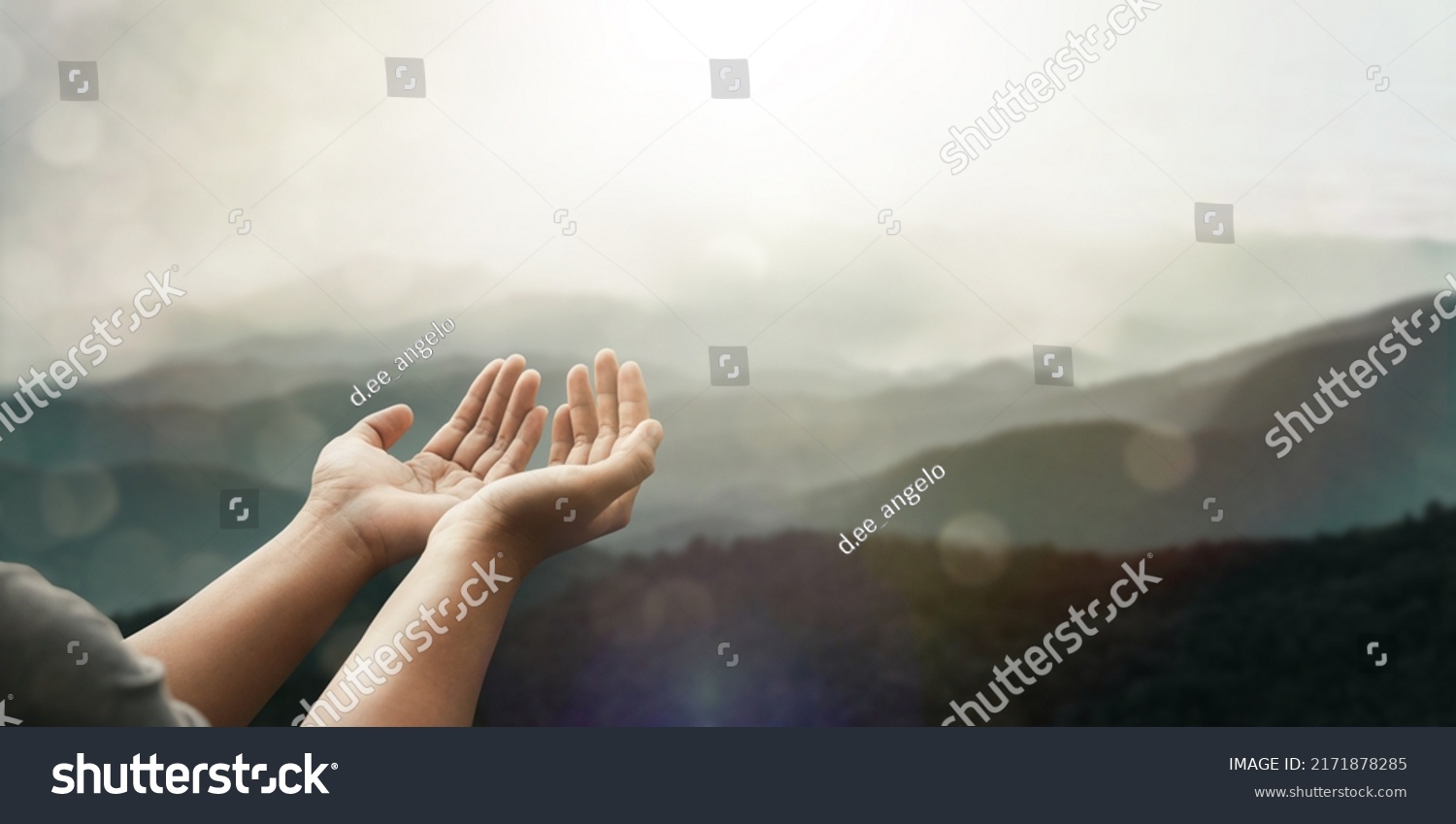 The two hands of a young man who prayed for hope from God Praise God concept. Pray, communicate. Mountain nature background. at sunrise #2171878285