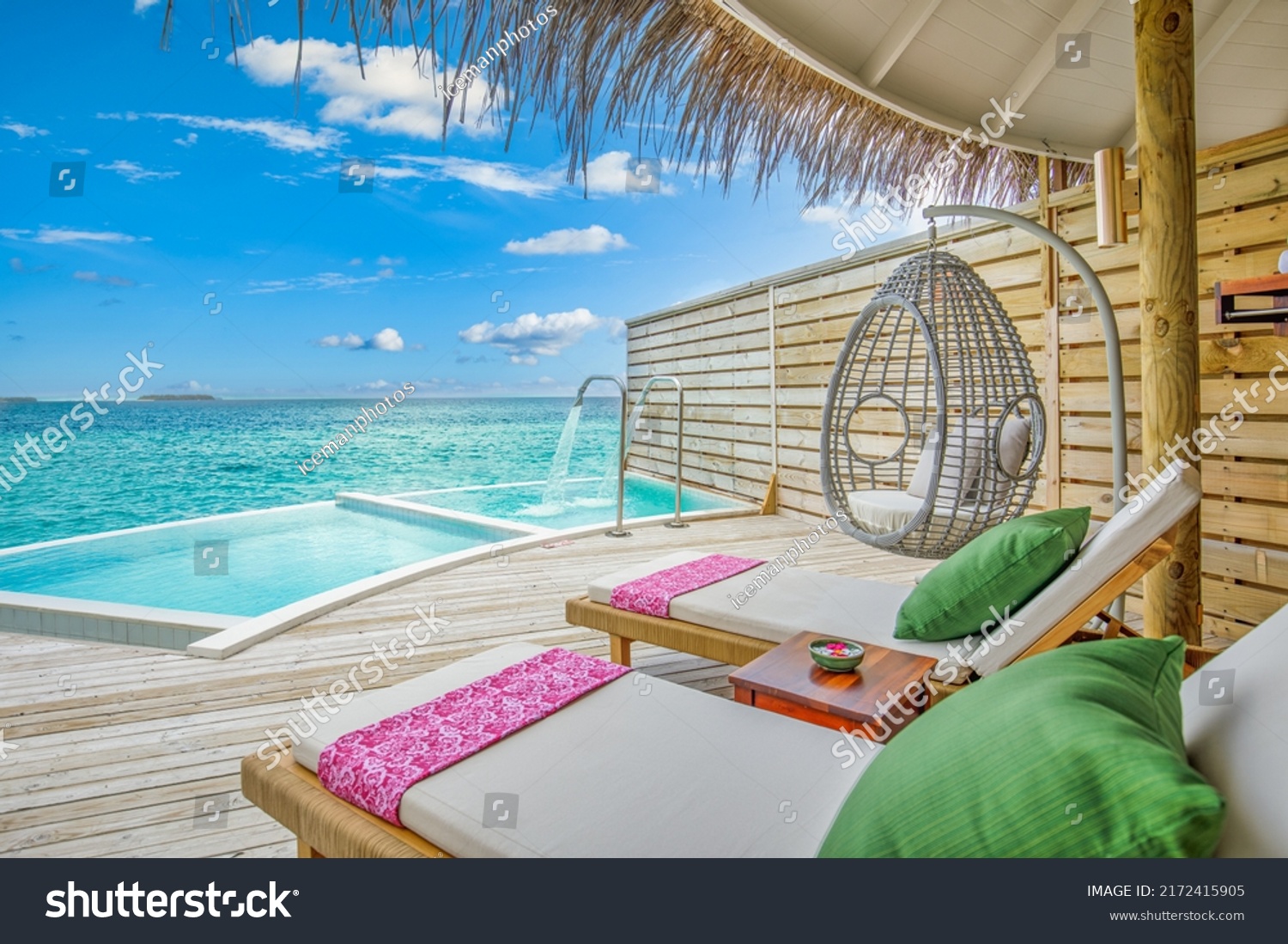 Fantastic over water villa, terrace view with sun beds chairs under umbrella, luxury pool hotel with stunning ocean view. Beautiful spa or wellness concept, recreational vacation resort tranquil area #2172415905