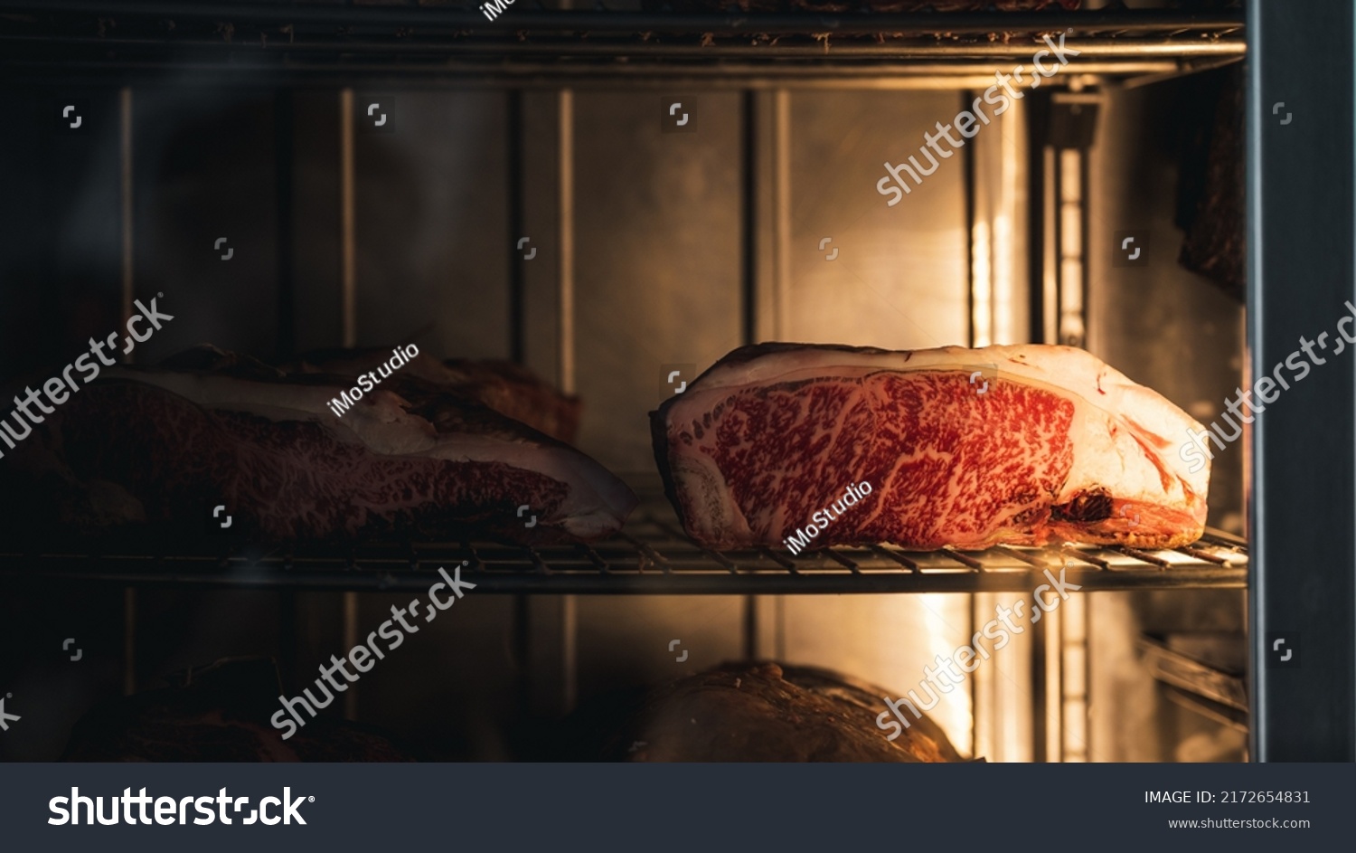Big piece of red dry aged beef, rib eye at a butcher, steak in a glass store #2172654831
