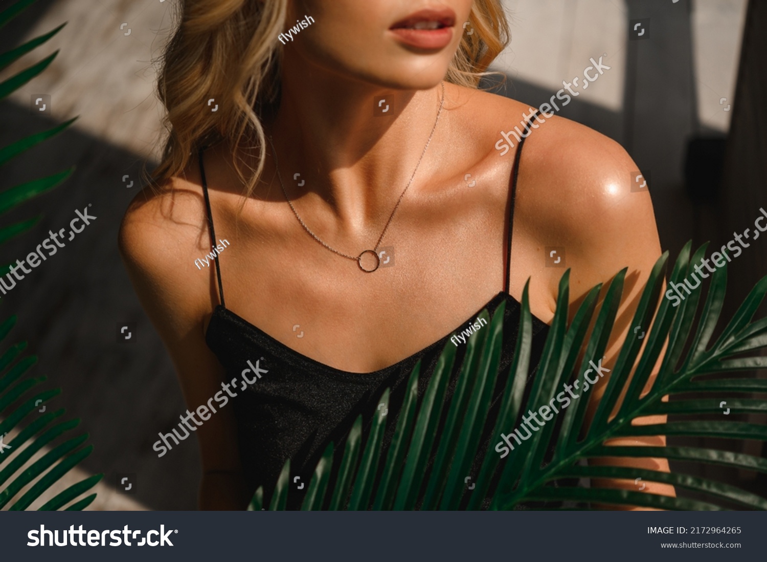 Attractive blonde woman in a black silk tank top and neck jewelry #2172964265